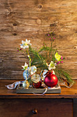 Christmas-tree baubles used as vases for hellebores and white pine branches