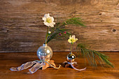 Christmas tree baubles converted into vases for Christmas roses and silk pine branches
