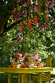 Tisch mit Dahlien und Früchten
