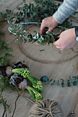 Tying a wreath of eucalyptus leaves and hyacinths