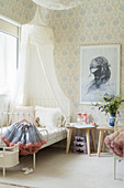 Canopied bed and pastel wallpaper in girl's bedroom
