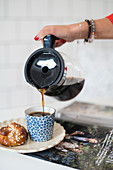 Kaffee wird in Kaffeebecher gegossen