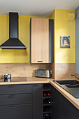 Moderne Küche in Schwarz und Gelb und mit Holz