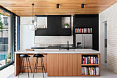 Open kitchen with fronts in wood and black in front of the window front