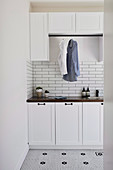 Fitted wardrobes with clothes rails in a classic laundry room