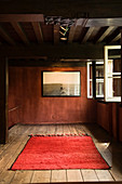 Wandbild und roter Teppich als schlichte Dekoration in restauriertem Antwerpener Wohnhaus