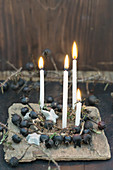 Wreath of black, dried rose hips with four candles and birch-bark stars