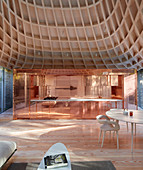Lounge, copper kitchen and funnel-shaped ceiling in open-plan interior