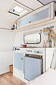 Pale blue kitchen area in lovingly renovated 80s caravan