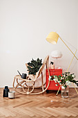 Rattan rocking chair, house plant, watering can, red cabinet and standard lamp