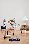 Various ornaments on side table and on pale parquet flooring