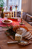 Bread, cheese and pastries on festively set, rustic wooden table