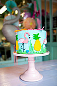 Cake ornately decorated with flamingo and pineapple motifs
