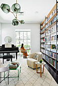 Living room with floor-to-ceiling bookshelf, piano and desk in modern bay window