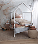 Fairytale children's room in natural tones with a cot in the shape of a house