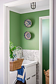 Washing machine and sink in a green alcove with a tile base