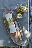 Wiesenblumensträußchen und Serviette mit Blütendeko