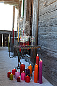 Hot drinks in hand-painted glasses next to candelabra and pillar candles in snow