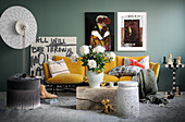 Artworks and yellow sofa against grey wall in living room
