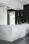 Elegant, white designer kitchen with large island counter