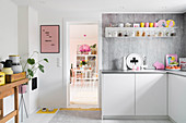 Grey-and-white kitchen with colourful accents of colour provided by ornaments and utensils