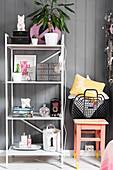 Shelving unit against wall next to pink wooden stool
