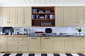 Long kitchen counter with beige panelled doors in country-house style