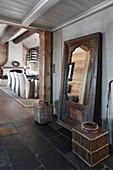Rustic full-length mirror in hallway next to open doorway leading into dining room with fireplace