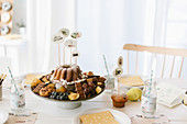 Sweets, fruits and cake on cake stand with decorative skewers