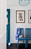 Blue-and-white striped scarf hanging on backrest of blue chair in hall