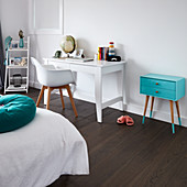 White desk, shell chair and turquoise chest of drawers in child's bedroom