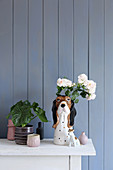 Collection of vases and dog figurines against blue-grey board wall