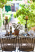 Gedeckter Tisch mit Pflanze, Kerzenhalter, Wasserkrug und Olivenöl