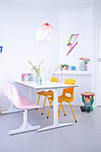 Dining table in white interior with bright accents of bold colour