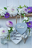 Heart decorations and small suspended bottles holding dahlias and asters