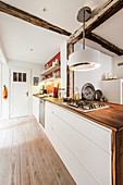 White fitted kitchen with wooden worksurface