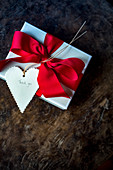 Geschenkpäckchen mit roter Schleife und Herzanhänger mit 'Thank you'