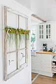 Ornamental window frame with summer garland on wall