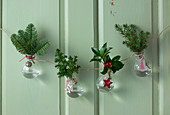 Handmade garland of glass vases holding Christmas arrangements