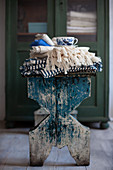 Folded tablecloths and cup on stool
