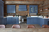 Blue cupboards in large country-house kitchen of log cabin