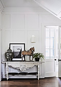 Antique console table with classical decoration in the hall with coffered wall