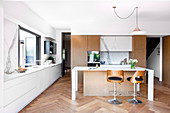 Modern open kitchen with kitchen island and herringbone parquet flooring