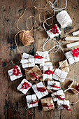 Small gifts with numbered, felt Christmas trees arranged and twine