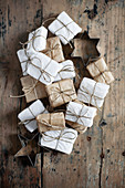 Small gifts wrapped in white and pale brown and star-shaped pastry cutters