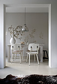 Open doorway leading into wintry dining room with white retro chairs