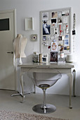 Transparent chair at grey console table below mood board on wall