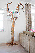 Lanterns hung from gnarled tree against back of sofa