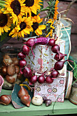 Wreath of small red onions decorating gardening utenslis