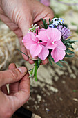 Sträußchen aus Hortensien, Vergissmeinnicht und Schnittlauchblüten wird gebunden